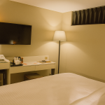 Sparkle Hotel ekonomik oda içinde çalışma masası, minibar, TV ve konforlu yatak