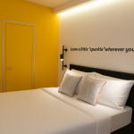 Sparkle Hotel Standart Oda içinde çift kişilik yatak, sarı duvar dekoru ve modern aydınlatmalar