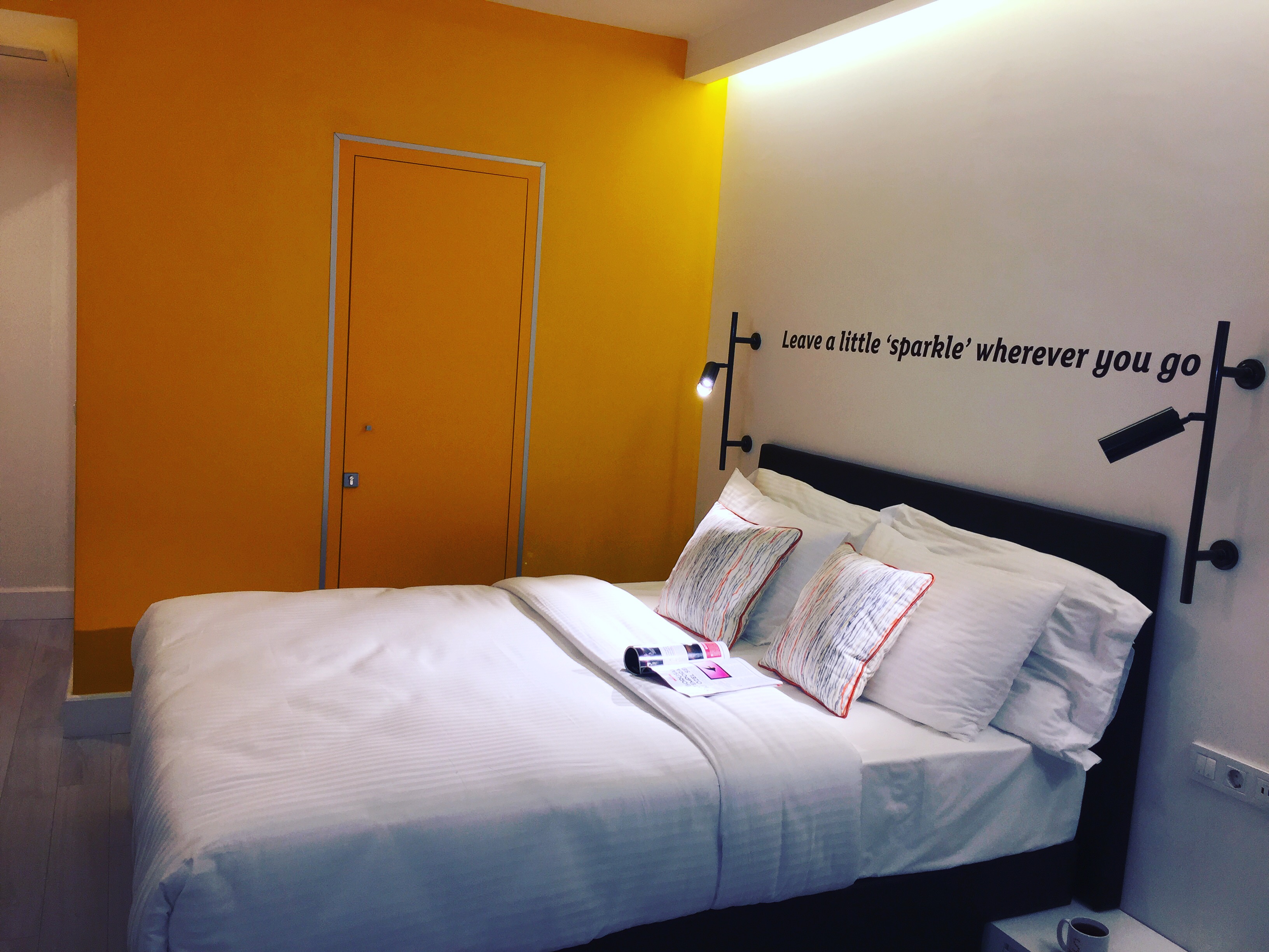 Turuncuı ve beyaz tonlarda dekore edilmiş, konforlu yatak ve modern aydınlatmalı Sparkle Hotel Deluxe Oda