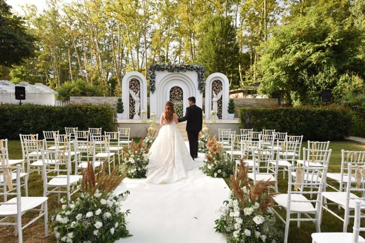 Gelin ve damadın açık hava nikah alanına yürüdüğü, çiçeklerle süslenmiş beyaz konseptli kır düğünü mekanı – Event Garden İstanbul