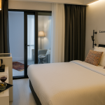 Sparkle Hotel Junior Suit içinde modern yatak odası, oturma alanı ve ikram sunumu bulunan şık oda tasarımı